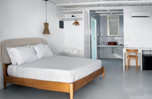 a bedroom with a large bed and a kitchen at Frati Villas Beachfront in Perivolos