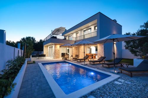 a house with a swimming pool in front of it at CROWONDER Villa Bura with Heated Swimming Pool and Jacuzzi in Privlaka