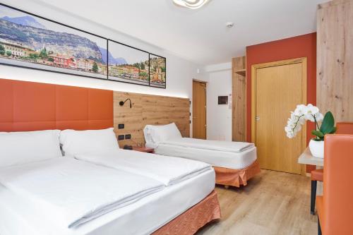 a hotel room with two beds and a painting on the wall at Residence Hotel Miralago in Pergine Valsugana