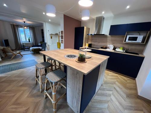 - une cuisine avec une table et des tabourets en bois dans l'établissement Les deux maisons - Tolbiac - Maison 8 personnes vue pistes proche lac, à Gérardmer