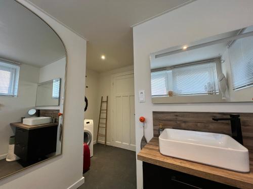 une salle de bain avec un lavabo blanc et un miroir dans l'établissement Les deux maisons - Tolbiac - Maison 8 personnes vue pistes proche lac, à Gérardmer