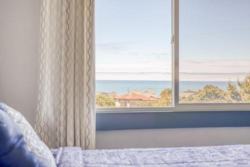 a bedroom with a window with a view of the ocean at Sea Haven in Lincoln City