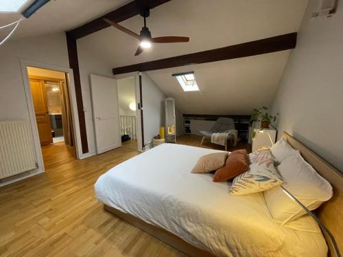 a bedroom with a large white bed with a ceiling at Maison Chic familiale avec Jardin in Gennevilliers