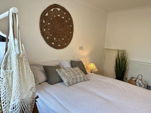 a bedroom with a bed with a basket hanging on the wall at Amazing Cambridge house in Chesterton