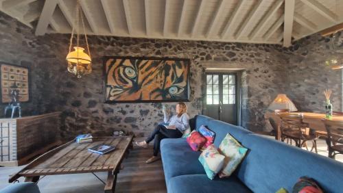 a woman sitting on a couch in a living room at Solar dos limas in Criação Velha