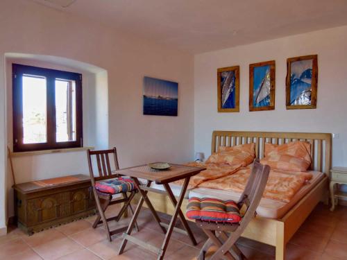 a bedroom with a bed and a table and chairs at Appartement Melchior - Turm Krk in Sveti Vid-Miholjice