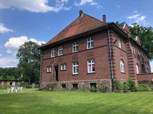 Un gran edificio de ladrillo rojo con ventanas blancas. en Gästezimmer Vermietung Reinstorf, en Reinstorf