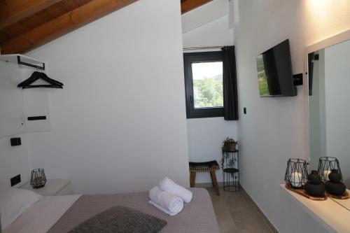 a bedroom with a bed and a tv on a wall at Saos Terra Suites in Samothráki