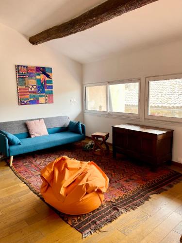 un salon avec un canapé bleu et une table dans l'établissement A spacious, sunny & calm loft in Avignon’s heart, à Avignon