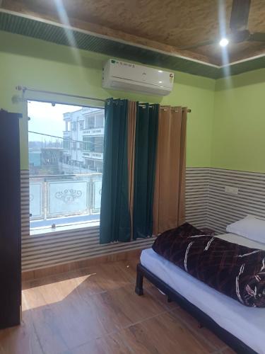 a bedroom with a bed and a large window at Purnotsav in Rishīkesh