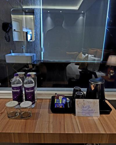 a counter with two bottles of water and a sink at Victorian Elegance Luxury Stays in Amritsar