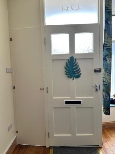 a white door with a pineapple decal on it at Taylor & Miller's Maisonette in North Walsham