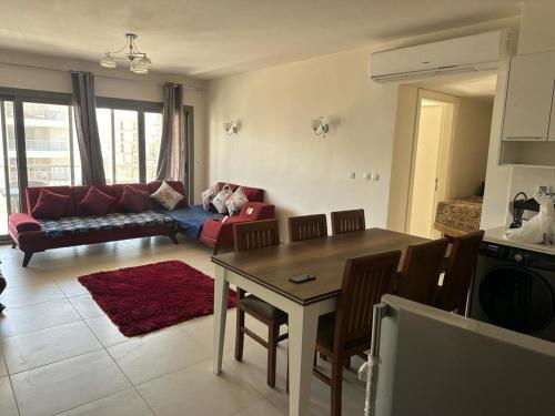 a living room with a table and a red couch at Marassi Marina Chalet in El Alamein