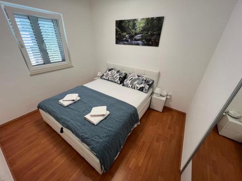 a bedroom with a bed with two towels on it at Apartment sea Lux in Povljana