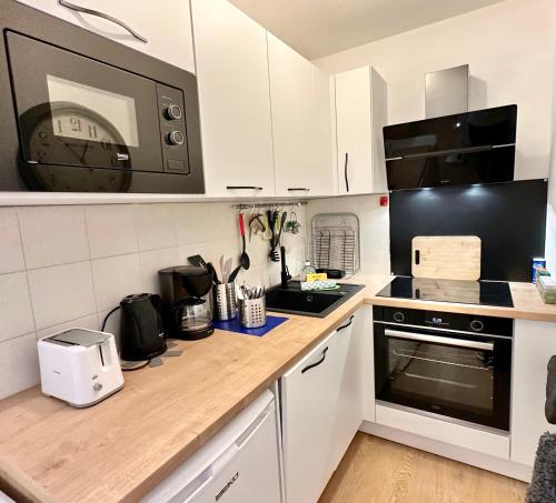 une cuisine avec un comptoir avec un micro-ondes dans l'établissement Au coeur d'Antibes - Clim, piscine et parking, à Antibes