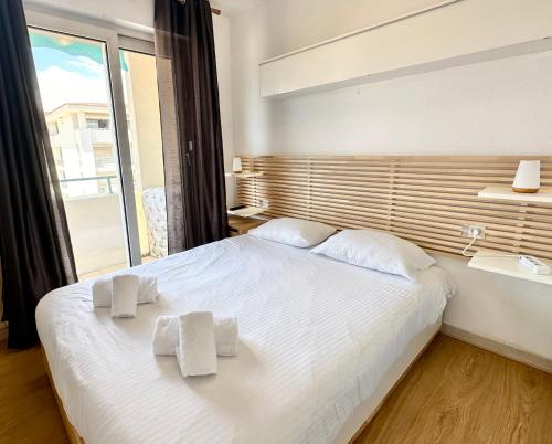 une chambre avec un lit blanc avec des serviettes dessus dans l'établissement Au coeur d'Antibes - Clim, piscine et parking, à Antibes