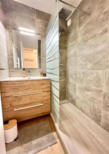 une salle de bain avec une douche, un lavabo et un miroir dans l'établissement Au coeur d'Antibes - Clim, piscine et parking, à Antibes