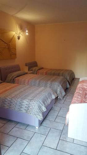 a bedroom with two beds and a tiled floor at B&B Ai Prati in Bergamo