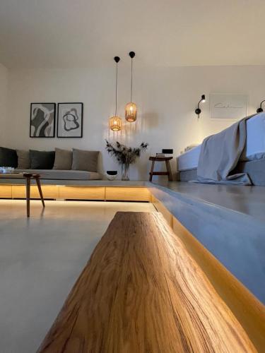 a living room with a couch and a wooden table at Hideaway Syros in Megas Gialos - Nites