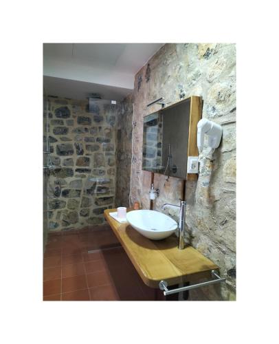 a bathroom with a sink and a stone wall at Il Sogno di Teresa in Camerota
