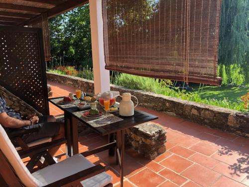 a table with food on it on a patio at Quinta do Troviscal in Castelo do Bode