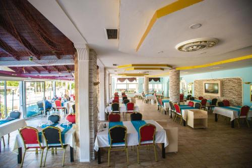un ristorante con tavoli e sedie con persone sedute a loro di Grand Hermes Hotel a Anamur