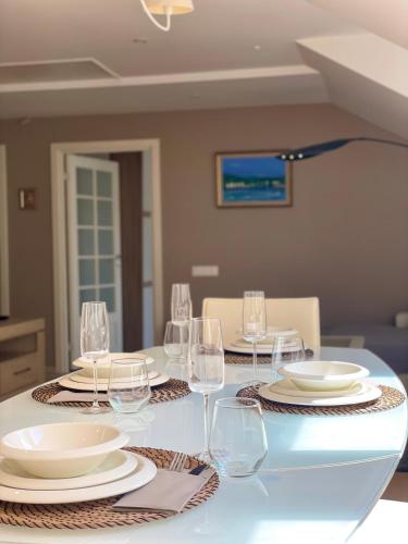 a table with wine glasses and plates on it at Jaukus butas prie jūros in Klaipėda