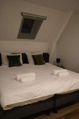 a large white bed with two white towels on it at Vughtse verblijven in Vught
