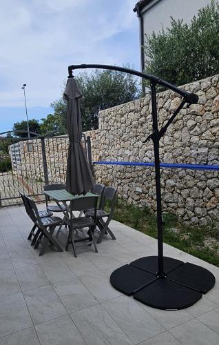 a umbrella and a chair and a table and a table at Art home relax in Cres