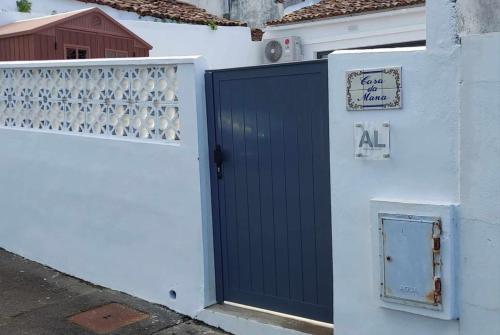 a garage door with aall sign on the side of a house at Casa da Mana in Feteira Grande