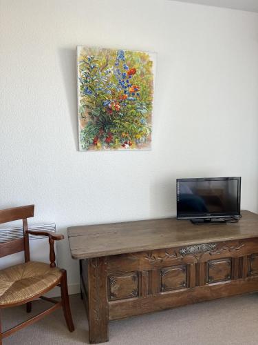 une télévision posée sur une table en bois à côté d'un tableau dans l'établissement Le Voilier bleu, à Saint-Jean-de-Monts
