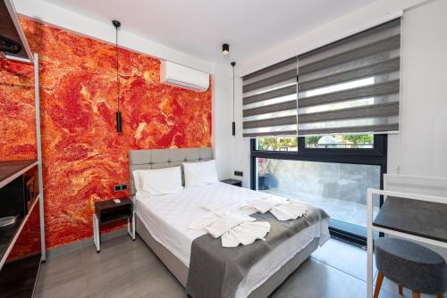 a bedroom with a bed and a red wall at EURONOVA HOTEL & SUiTES in Kemer