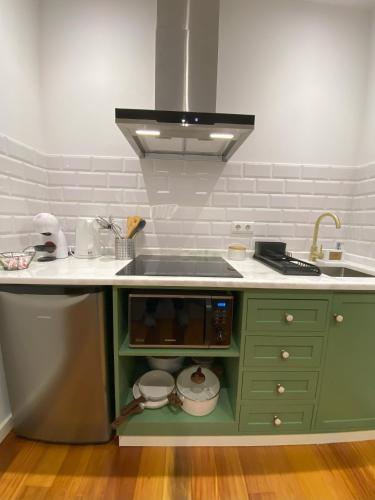 a kitchen with a sink and a stove top oven at Loft Surdo in Funchal