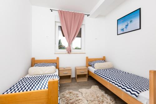 Dos camas en una habitación con ventana. en Apartment Mara by EL-PI TOURS, en Malinska