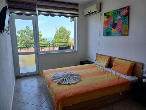 a bedroom with a bed and a large window at Крин in Sinemorets