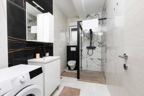 Un baño blanco con inodoro y ducha. en Apartment Mara by EL-PI TOURS, en Malinska