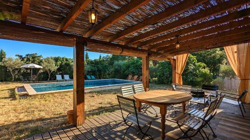 un patio avec une table et des chaises et une piscine dans l'établissement Villa avec piscine privée - vue sur vignoble, à 8 min de la plage, à Fréjus