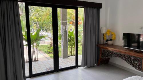 a living room with a sliding glass door at Rega house in Meliling