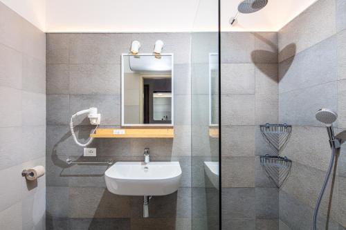 a bathroom with a sink and a mirror at Appartamenti BIANCO NERO in Lignano Sabbiadoro