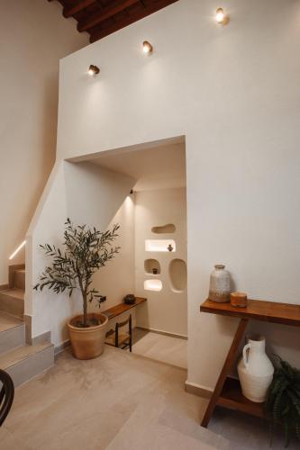 a room with a staircase with a potted plant at Noema Lindos - Athena Apartment in Líndos