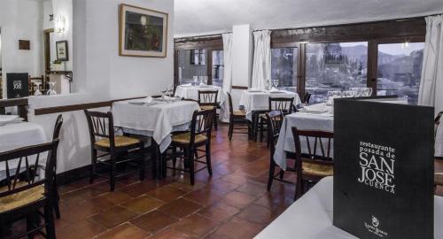a restaurant with white tables and chairs and a sign at Posada San José in Cuenca