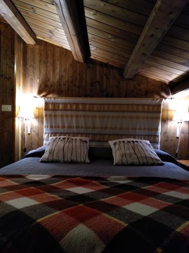 a bedroom with a large bed with two pillows at Agriturismo Volpignano in Collesano