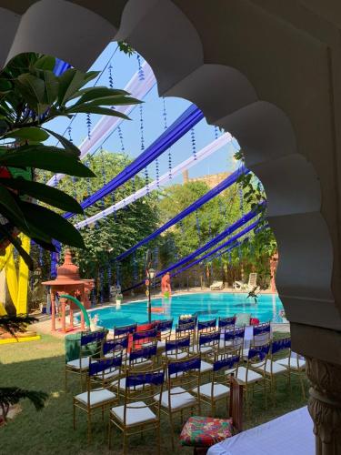 a group of chairs in front of a swimming pool at Hotel Bissau Palace in Jaipur