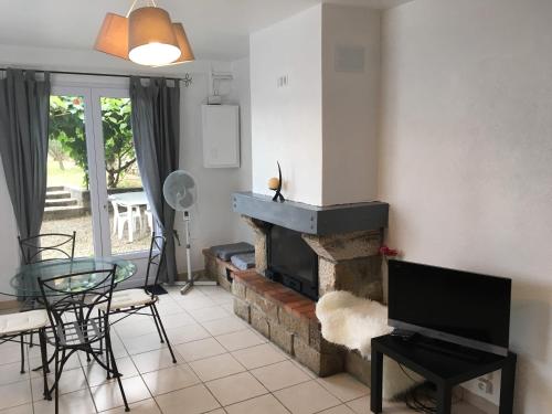 - un salon avec une cheminée, une table et des chaises dans l'établissement Au fil du Chassezac #Kiwi, à Chambonas