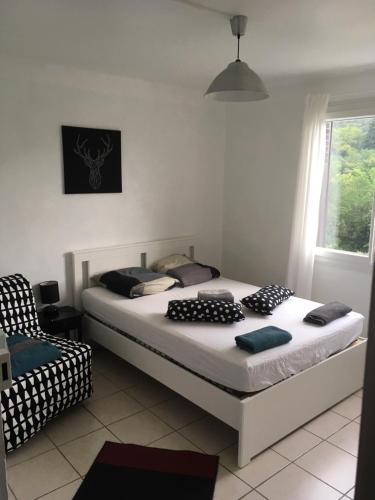 une chambre avec un lit et une chaise dedans dans l'établissement Au fil du Chassezac #Kiwi, à Chambonas