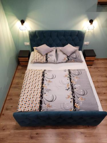a large bed with a blue headboard in a room at Apartamenty Pokoje Lawenda Wisła in Wisła