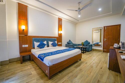 a bedroom with a bed and a chair and a table at Vrinda Anandam Resort in Vrindāvan