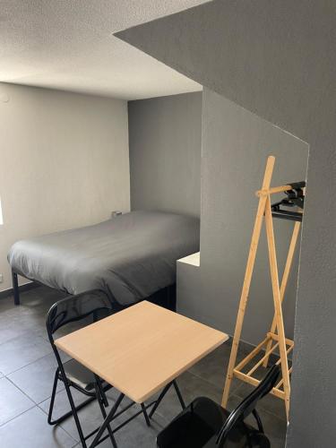 Cette chambre comprend un lit, une table et une échelle. dans l'établissement Studio 3 proche Fac climatisé, à Albi