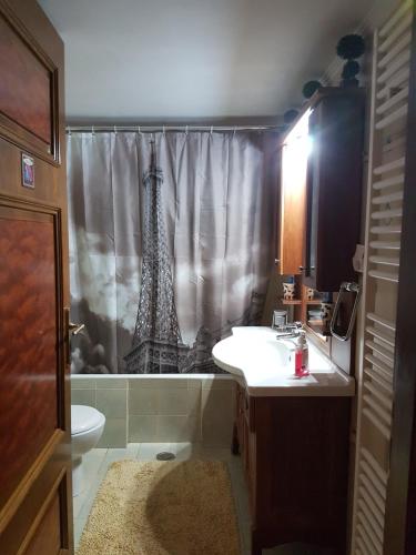 a bathroom with a sink and a shower with the eiffel tower at HoneyHouse in Kádhion