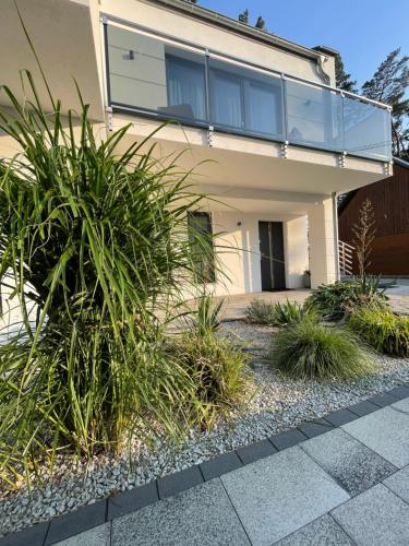 a house with a bunch of plants in front of it at Apartamenty Marco Polo in Dziwnówek